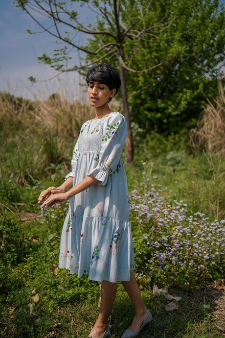 Grey Smocking Dress with square neckline and floral embroidery, model wearing it, side view