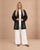 Model wearing the Guipure Botanical Lace Jacket by ZOY in black over white trousers, full length front view