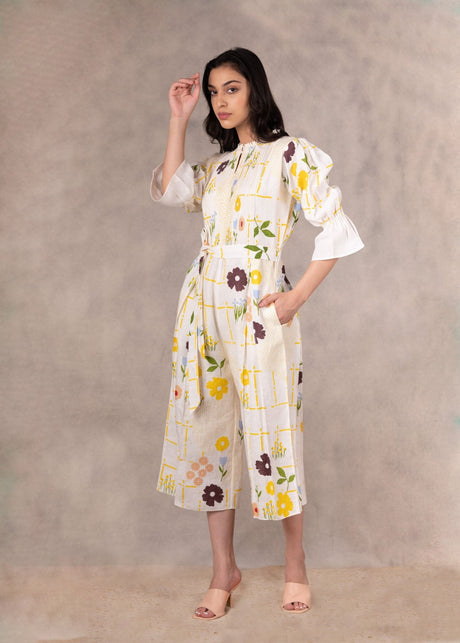 Hand block floral jumpsuit with ruffle bell sleeves, model with hand raised, front view