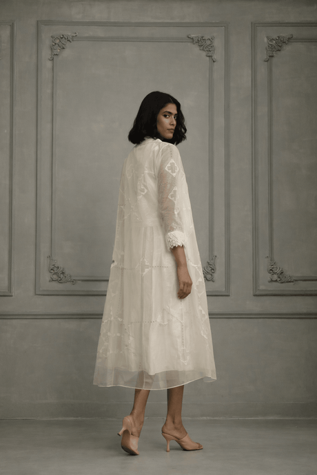 Model wearing the sheer ivory organza jacket over the dress, three-quarter back view