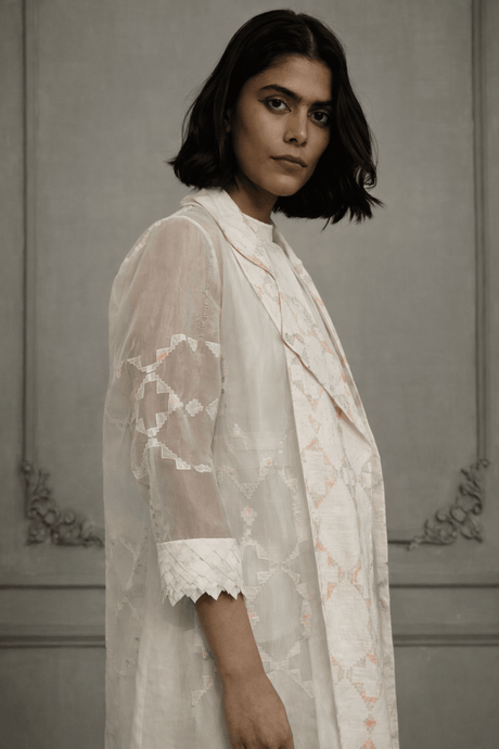 Close-up of the ivory organza jacket with applique sleeve and scalloped cuff