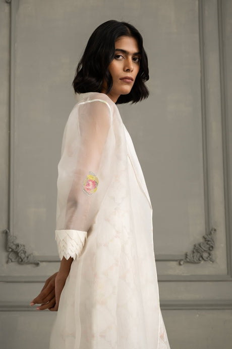 Close-up of the ivory organza jacket sleeve with applique flower and scalloped cuff