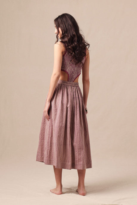 Back view of the Mauve Striped Bodysuit with back cutout worn with a striped midi skirt