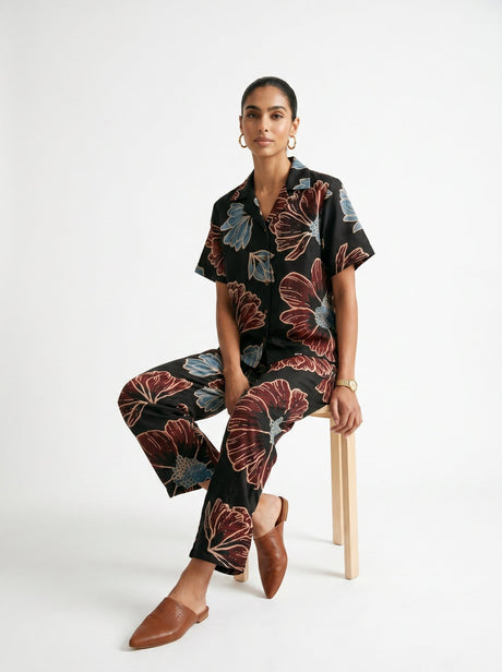 Model seated in the May Black Modal Floral Co-ord set showing the printed pants