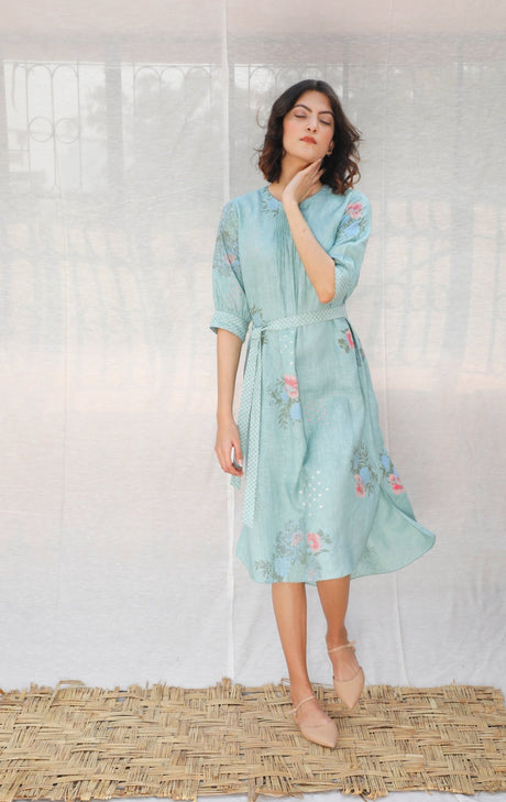 Model wearing the mint linen dress with elbow sleeves, hand at chin, three-quarter view