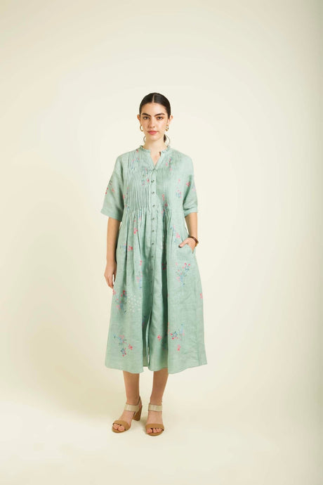 Mint linen printed dress front view with hand in pocket showing the pintuck yoke