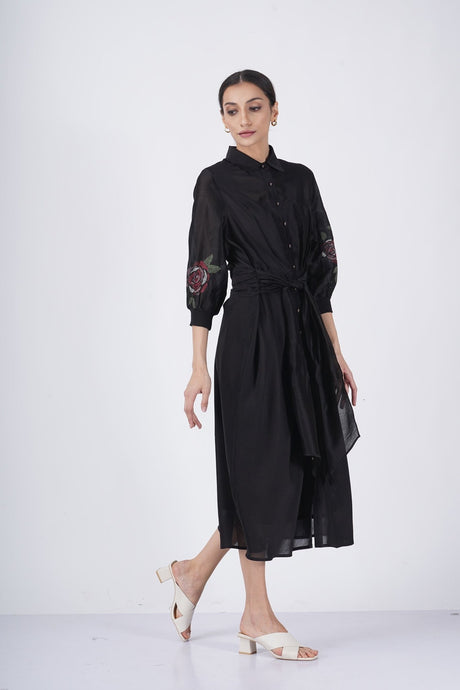 Model walking in the black rose printed sleeve dress with front button placket, three-quarter view