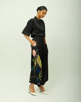 Psyflora black pinstripe shirt set with floral painted wide leg trousers and white heels, three quarter view