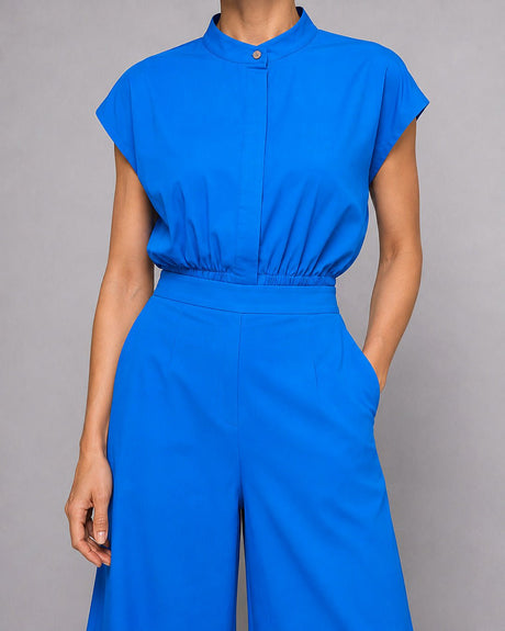 Close-up of the blue Sphara Cotton Top band collar, button and gathered waist