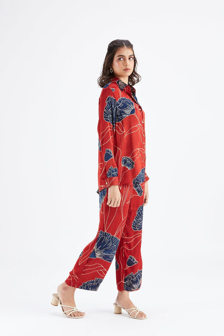 Model walking in the red Yuna co-ord set with floral shirt and pants, side view