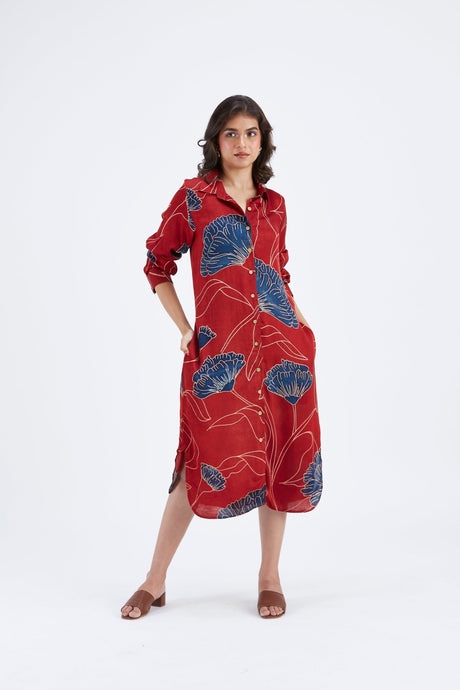 Model wearing the red Zae dress with rolled sleeves and hand in pocket, front view